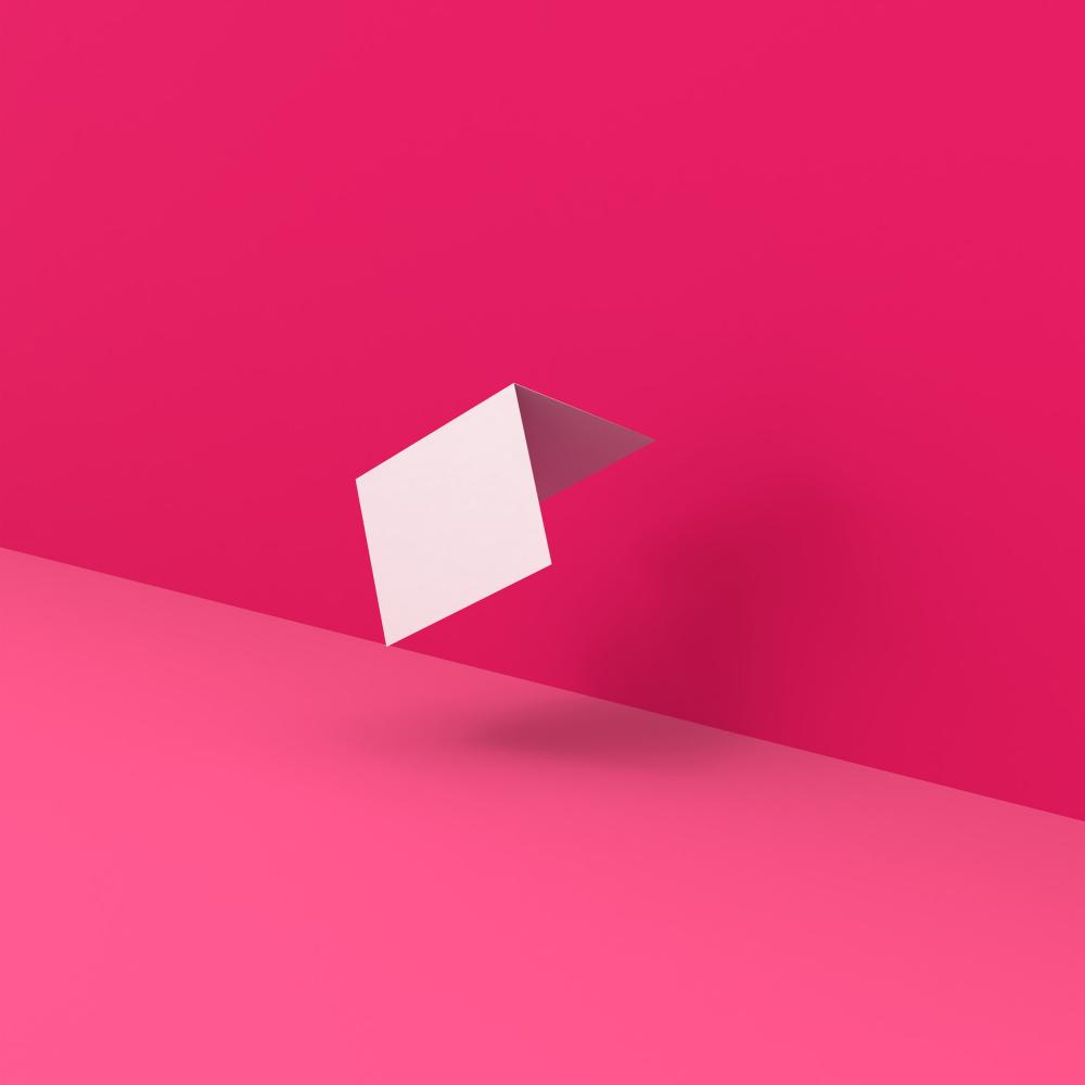 Carte pliée blanche et moderne sur un fond rose. Convient pour des cartes d’invitation, des cartes de vœux ou des cartes pliées.